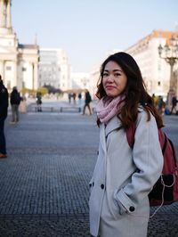 Portrait of beautiful woman standing in city