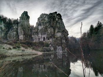 Scenic view of rocks by lake against sky