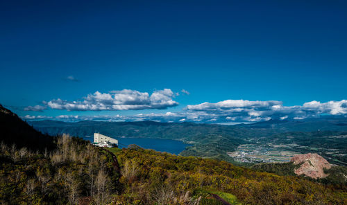 Scenic view of sea and mountains against blue sky