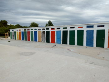 Multi colored umbrellas on beach against sky in city