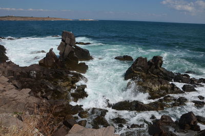 Rocks on sea shore against sky