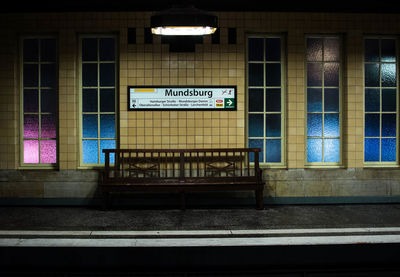 Empty bench at illuminated subway station