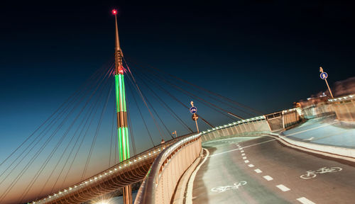 Illuminated bridge against sky at night