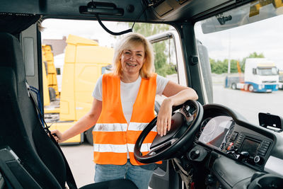 Mature woman standing in truck