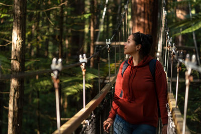 Young woman looking away in forest