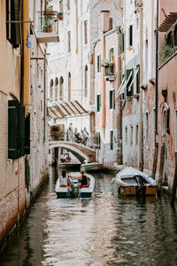 Boats in canal amidst buildings in city