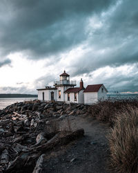 Buildings by sea against sky