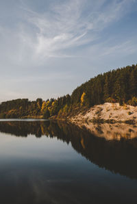 Scenic view of lake in forest against sky