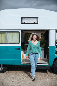 Woman walking against camper van