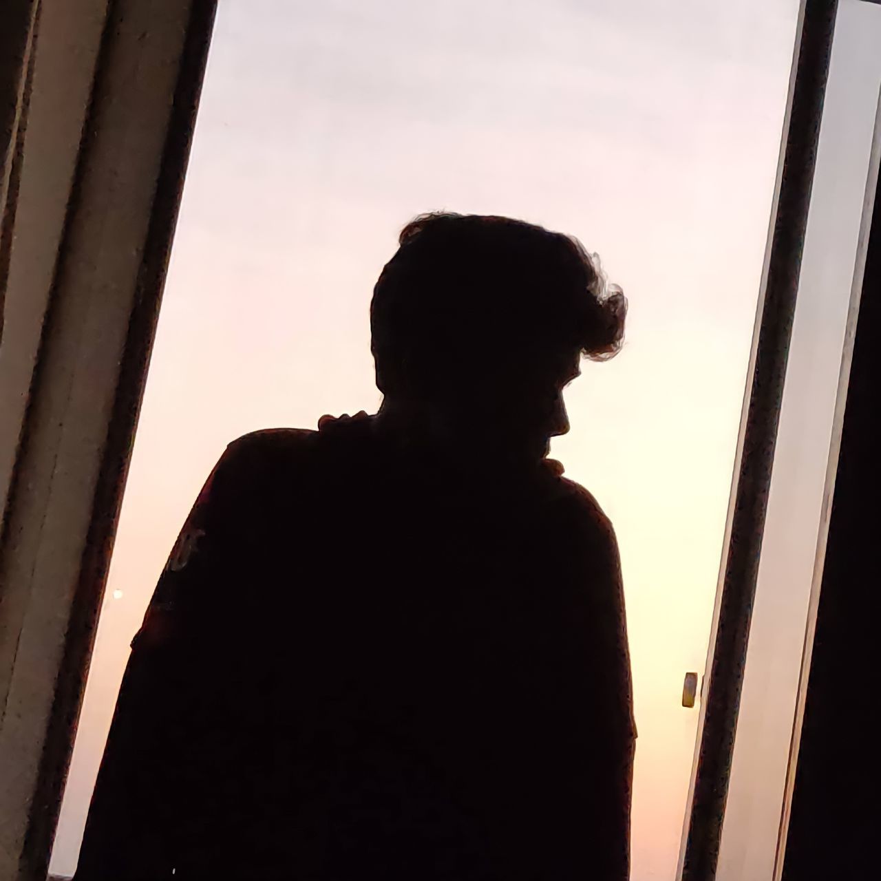 SILHOUETTE MAN LOOKING THROUGH WINDOW AGAINST SKY