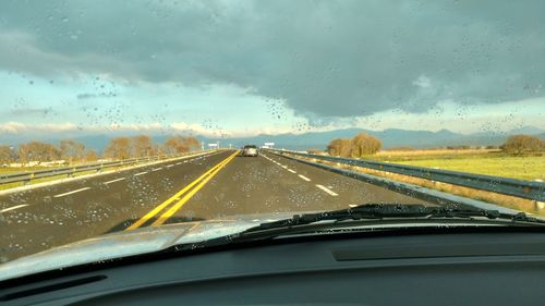 Highway seen through wet car windshield
