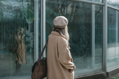 Woman wearing overcoat while standing outdoors