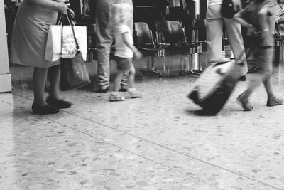 Low section of people standing on tiled floor