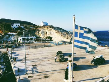 Scenic view of beach by buildings against clear blue sky