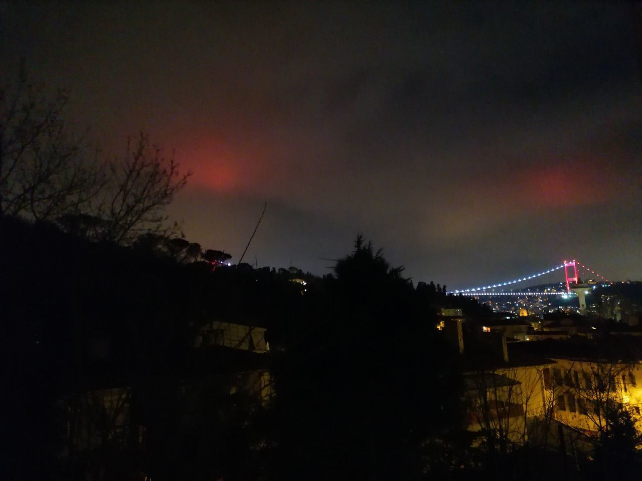 LOW ANGLE VIEW OF ILLUMINATED BRIDGE AGAINST SKY AT SUNSET