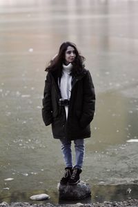 Full length portrait of young woman standing in winter