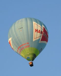 Low angle view of hot air balloon against clear blue sky