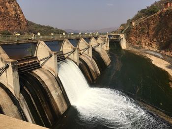 Scenic view of dam by river against sky