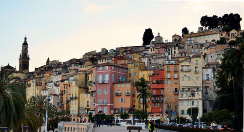 Buildings in town against sky during sunset