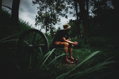 Man sitting on grass in forest