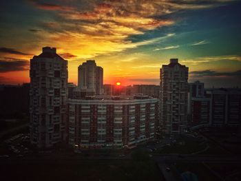 Skyscrapers in city at sunset