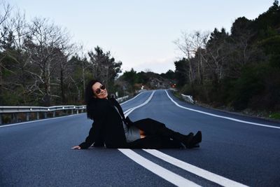 Full length of woman on road against trees