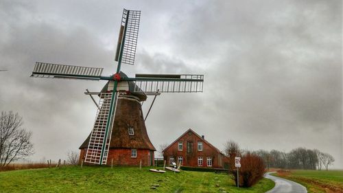 Traditional windmill on field against sky