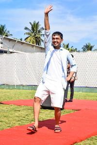 Full length of a smiling young man standing outdoors