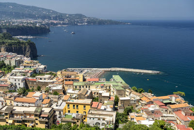 High angle view of townscape by sea against sky