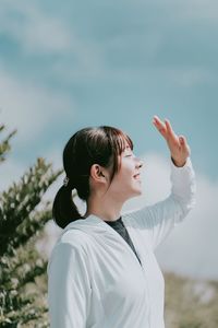 Portrait of woman standing against sky