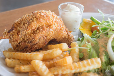 Close-up of fried chicken and french fries in plate