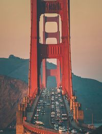 High angle view of vehicles on golden gate bridge against sky in city during sunset