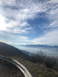 Road amidst field against sky