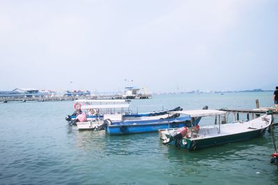 Boats moored on sea against clear sky