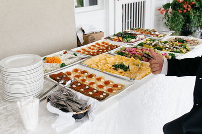 Cropped man gesturing thumbs up sign by food on table