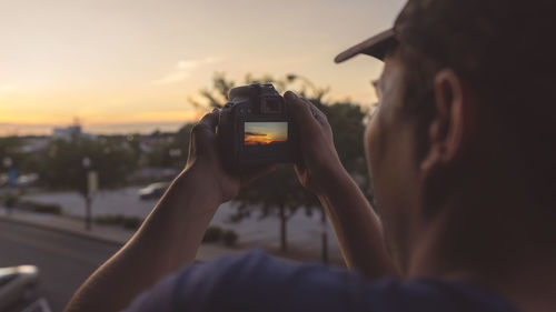 Portrait of man using mobile phone against sky