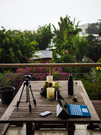 Laptop and bottle on table in balcony during rainy season