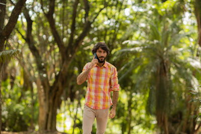 Young man at park on a beautiful sunny day with mobile phone.  working  leisure. green and nature 