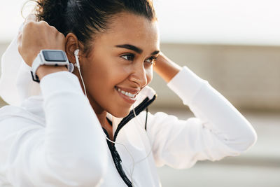 Close-up of smiling woman listening music