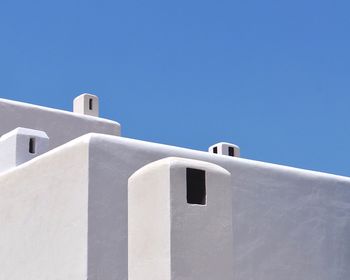 Low angle view of white building against clear blue sky