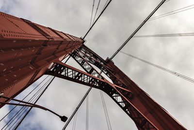 Low angle view of bridge against cloudy sky
