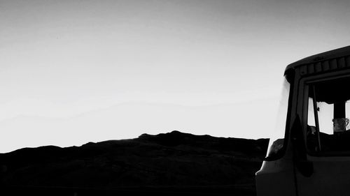 Silhouette mountain road against clear sky