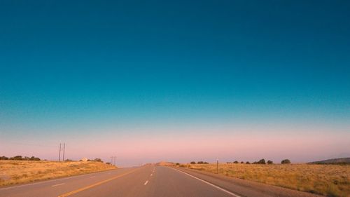 Road against clear blue sky