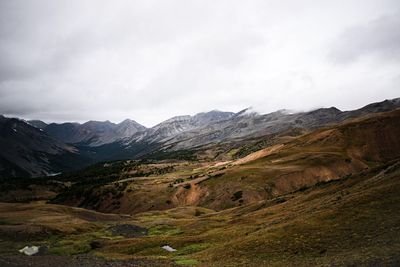 Scenic view of mountains against cloudy sky