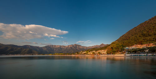 Scenic view of lake and mountains against blue sky
