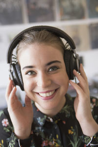 Smiling young woman listening to music in a record store
