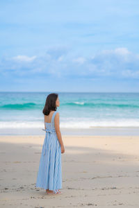 Woman standing on beach against sea