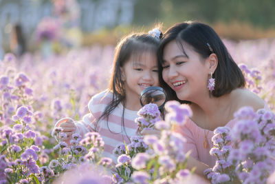 Close-up of smiling girl with flowers on plants