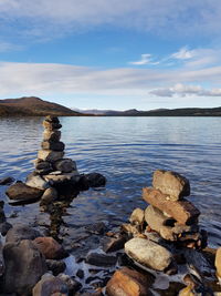 Stack of rocks in sea against sky