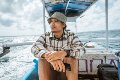 Portrait of man sitting on sea